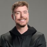 A photo of MrBeast against a wall of dollar signs.
