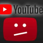 A photo of a man holding up the YouTube application on a smartphone.