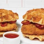 a man eating chicken from a kfc vending machine