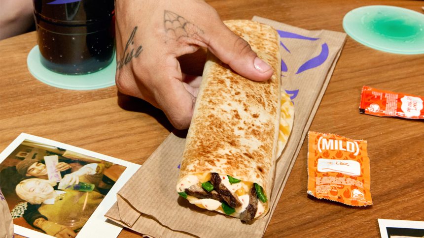 Taco Bell logo next to runner with Taco Bell wrappers on table
