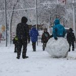 students play in snow at school