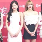 Blackpink standing in elegant attire on a red carpet