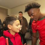 Ishowspeed and blind fan in red coat staring at each other