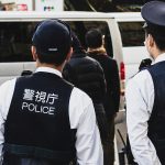 Two Japanese police officers stand on the street.