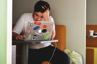 Student struggling in front of laptop