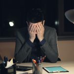 An office worker with his head in his hands.