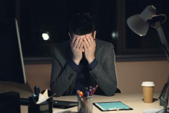 An office worker with his head in his hands.