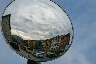 A photo of a traffic mirror reflecting a residential street.