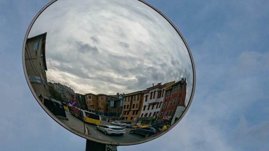 A photo of a traffic mirror reflecting a residential street.