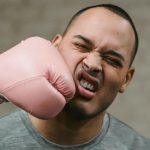 A photo of a man being punched in the face with a boxing glove.