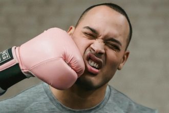 A photo of a man being punched in the face with a boxing glove.