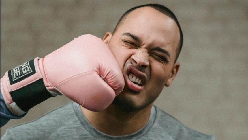 A photo of a man being punched in the face with a boxing glove.