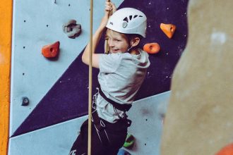 A photo of a child climbing a rock wall.