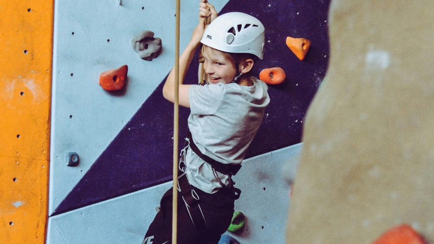 A photo of a child climbing a rock wall.
