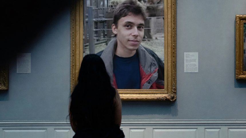 A woman sits in a museum looking at a picture frame with Jawed in 'Me at the zoo.'